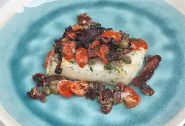 Baccalà al forno con capperi, pomodori secchi e peperoni cruschi