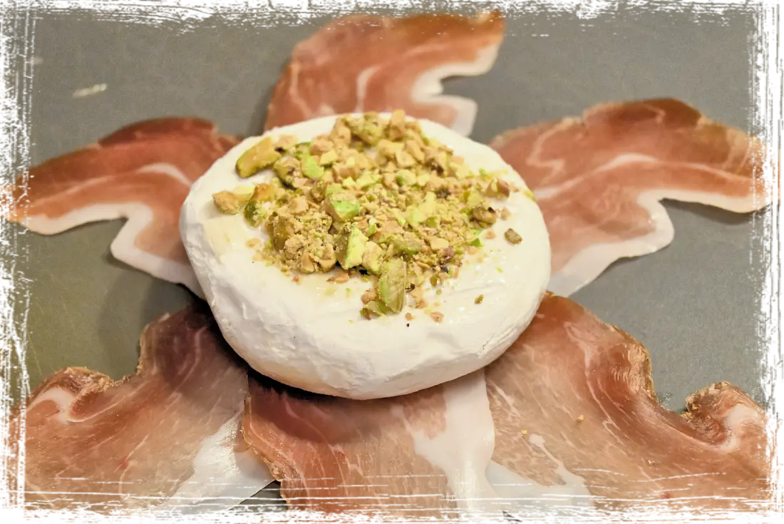 Tomino al forno con pistacchi, miele e speck Tomino al forno con pistacchi, miele e speck